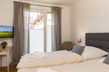 Helles Schlafzimmer mit Doppelbetten und Zugang zur Terrasse
